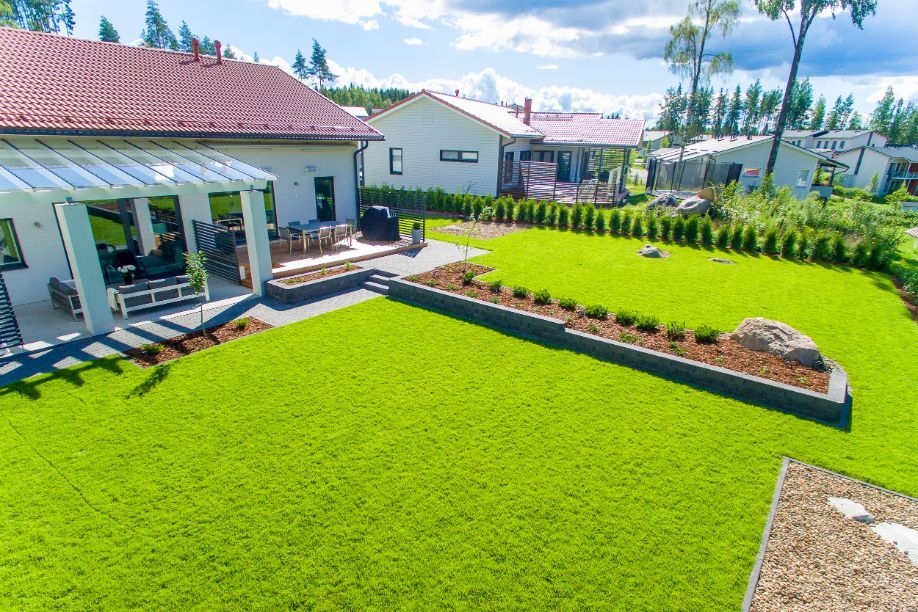 Vihreä nurmi talon takapihalla